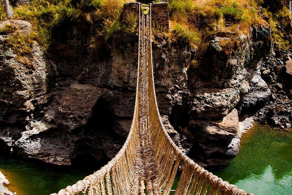 uma ponte de corda sobre um rio em uma montanha