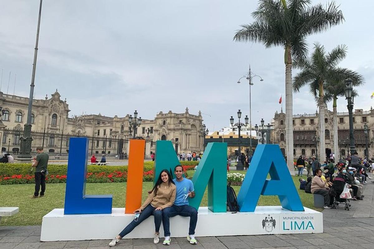 Un hombre y una mujer sentados frente a las letras lama
