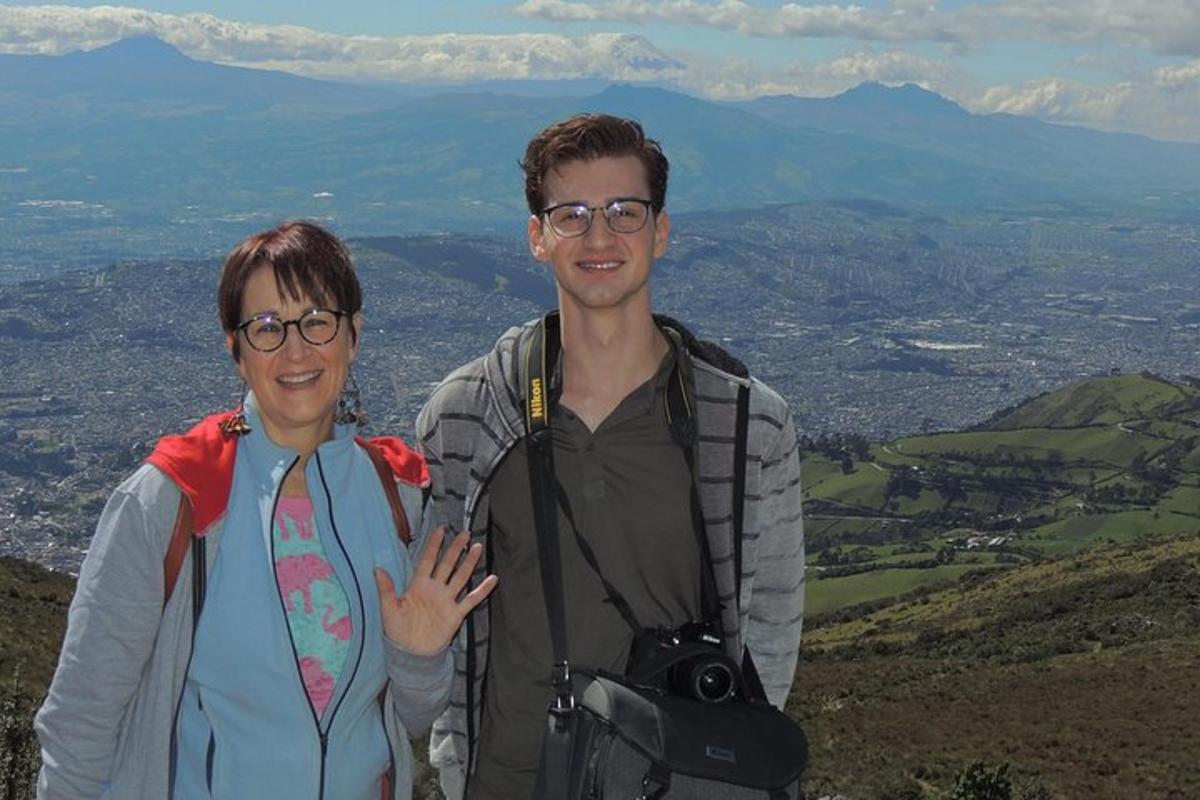a man and woman standing on top of a mountain