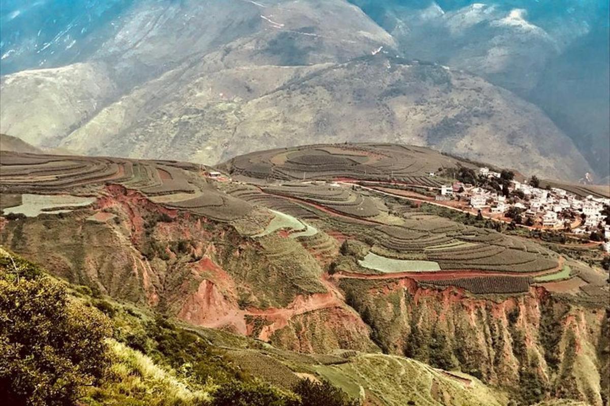 uma vista de uma montanha com uma vila em uma colina