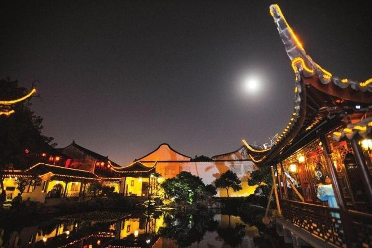 a night view of a building with the moon in the sky