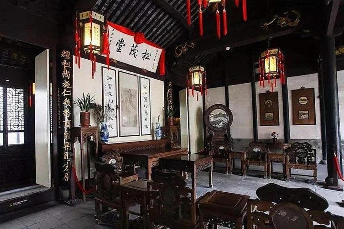 a room with a clock and tables and chairs