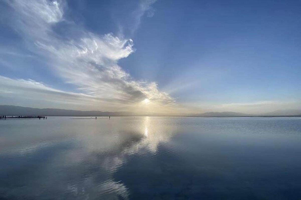 a large body of water with the sky and clouds