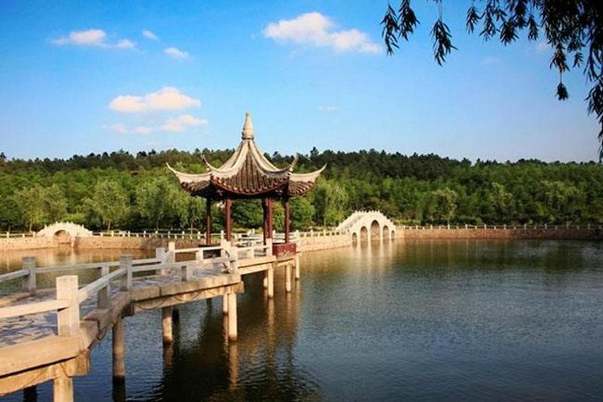 a pagoda in the middle of a lake with a bridge