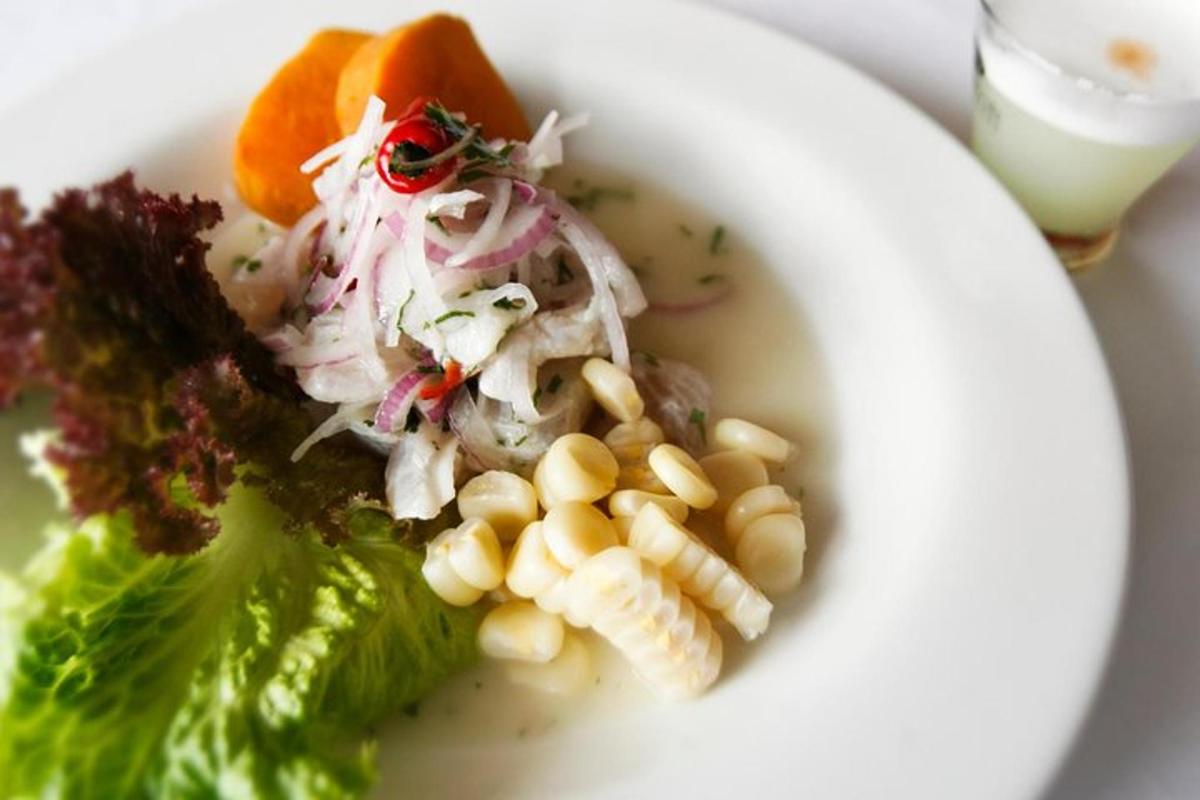 Un tazón blanco de sopa con maíz y verduras.