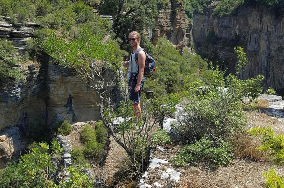 un uomo con uno zaino in piedi sul fianco di una montagna