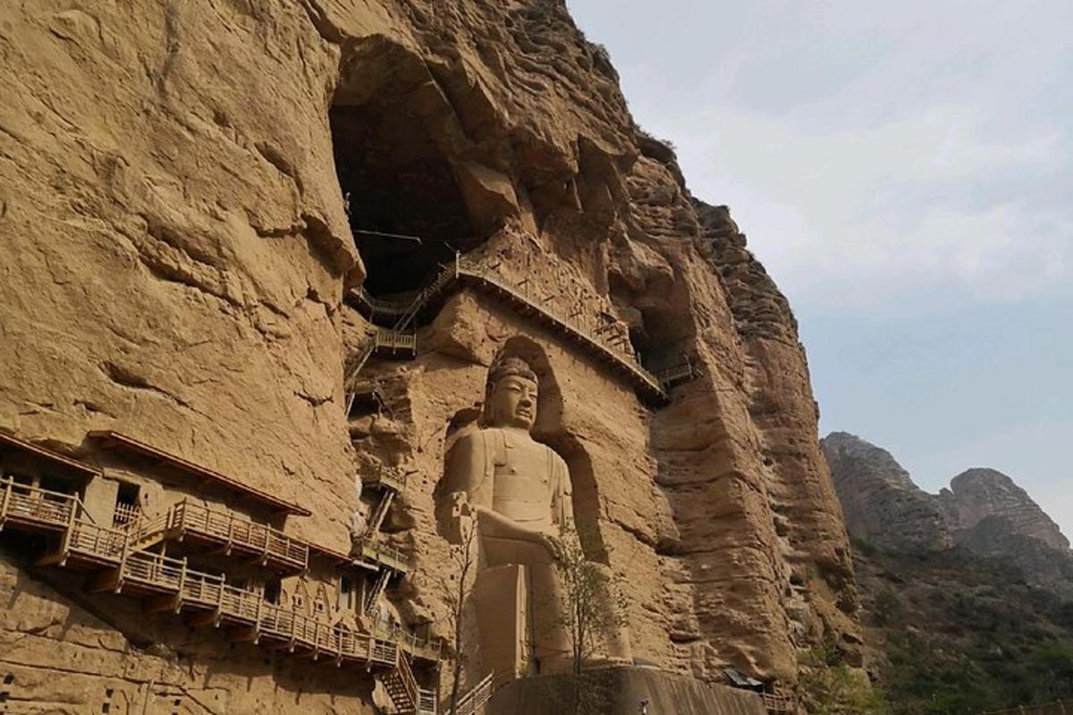 a statue on the side of a rock wall