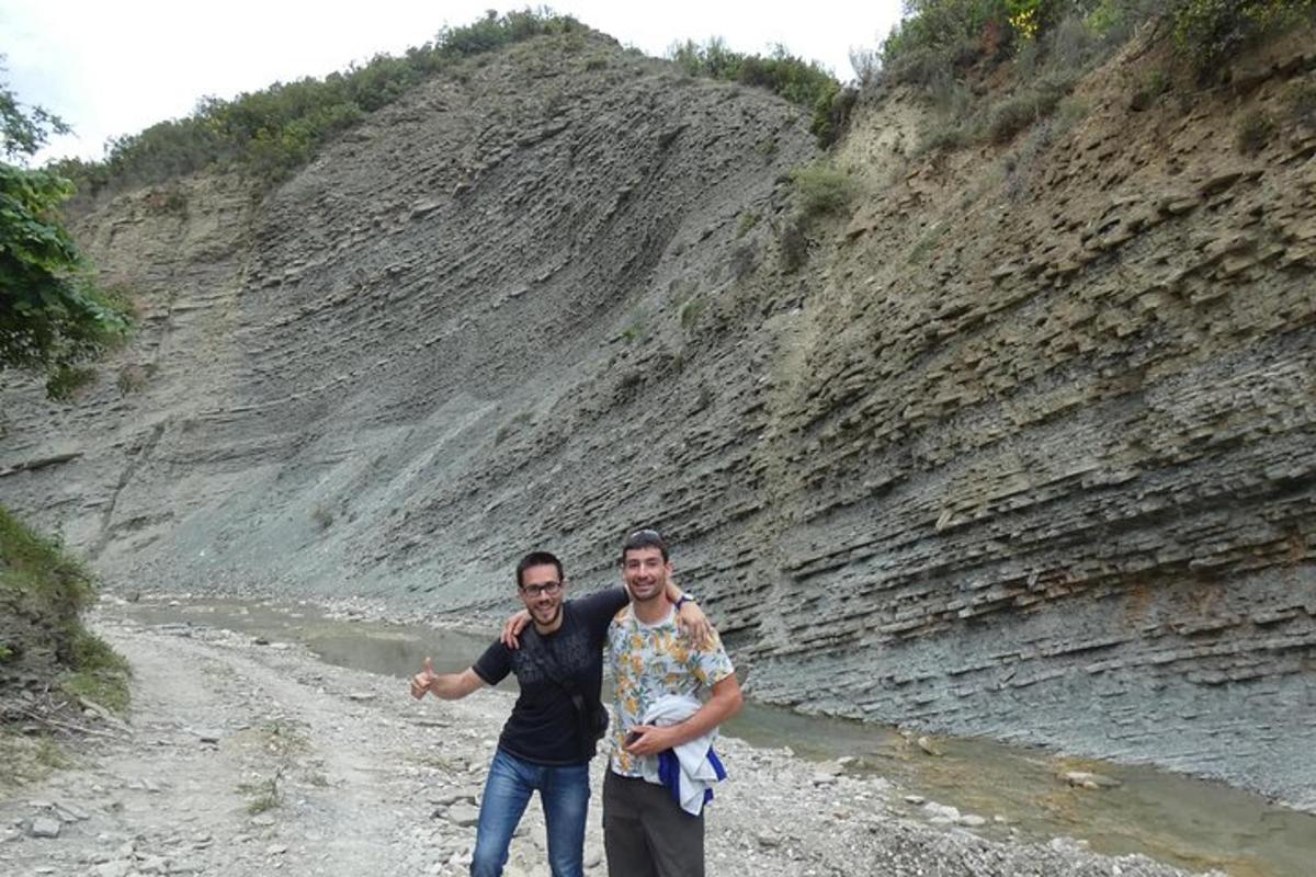dua lelaki berdiri di atas jalan tanah di sebelah sungai