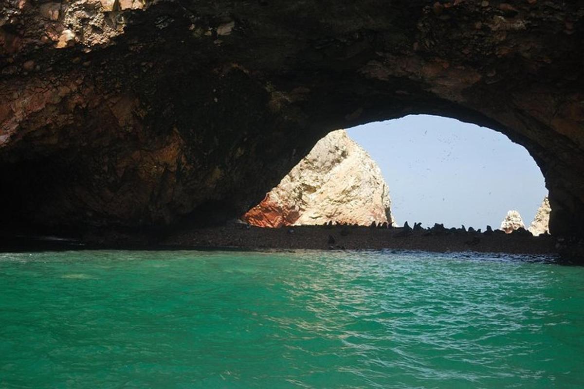 una cova amb un estany d'aigua blava al davant