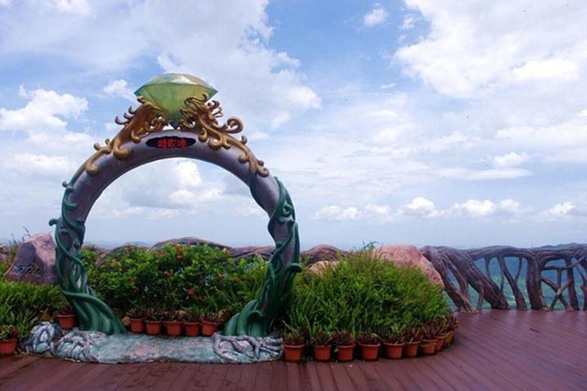 a statue of an arch with plants on a roof