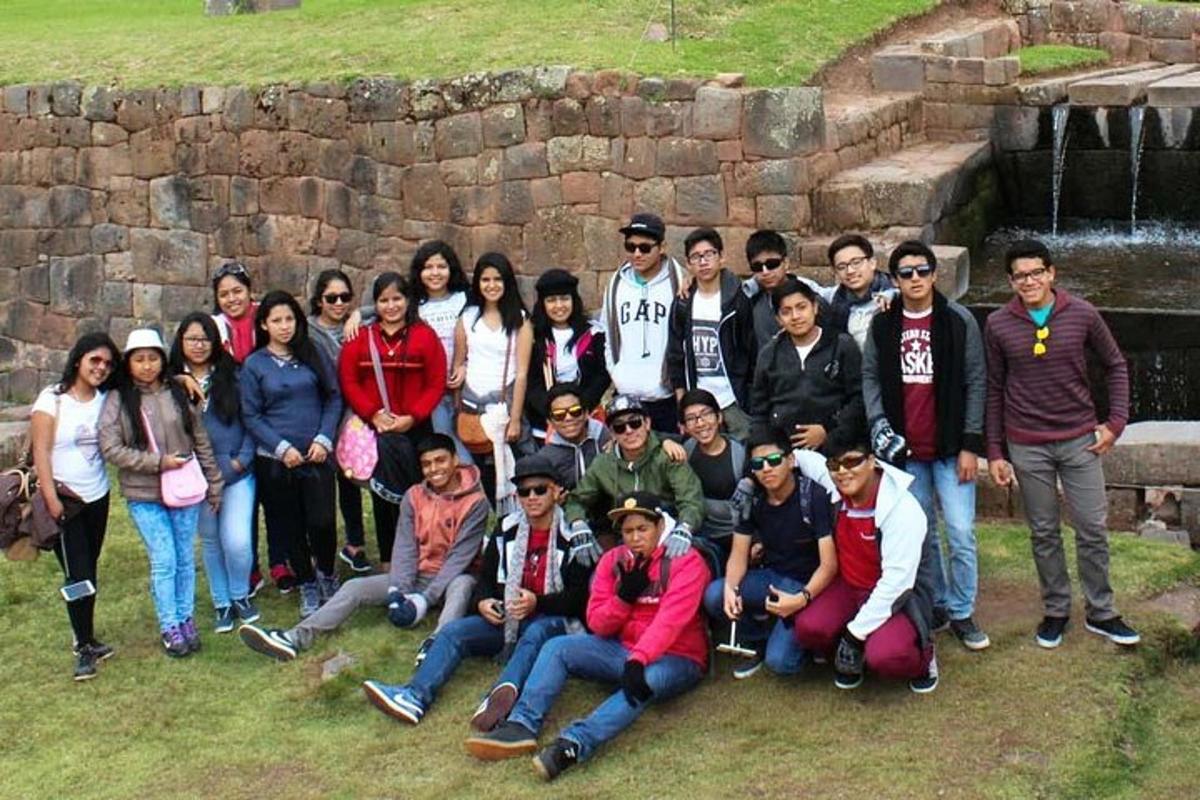 un gruppo di persone in posa per una foto davanti a un muro