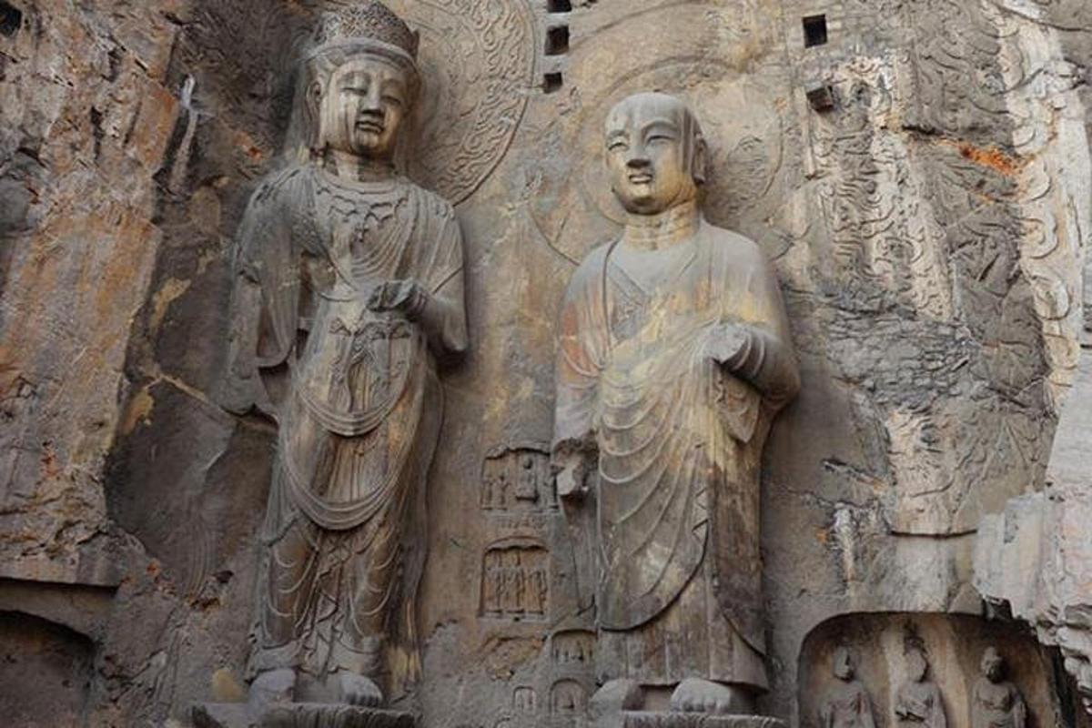 two statues on the side of a stone building