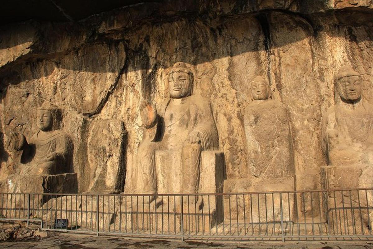 a large stone wall with statues in a cave