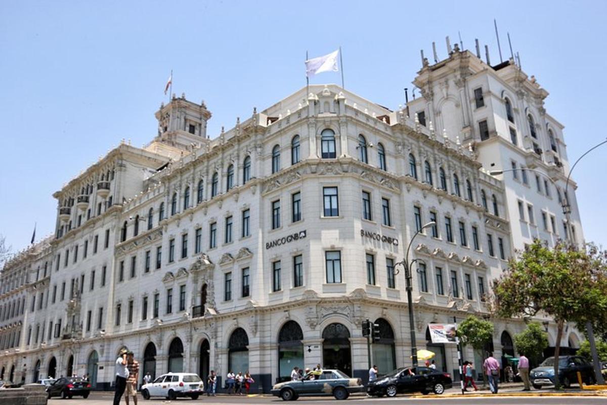 một tòa nhà lớn màu trắng với những chiếc xe đậu ở phía trước