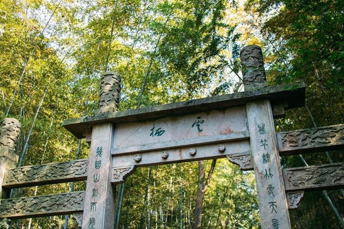 a gate in a forest with writing on it