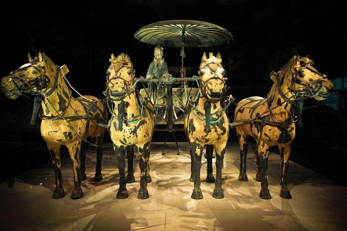 a statue of horses pulling a carriage with a man