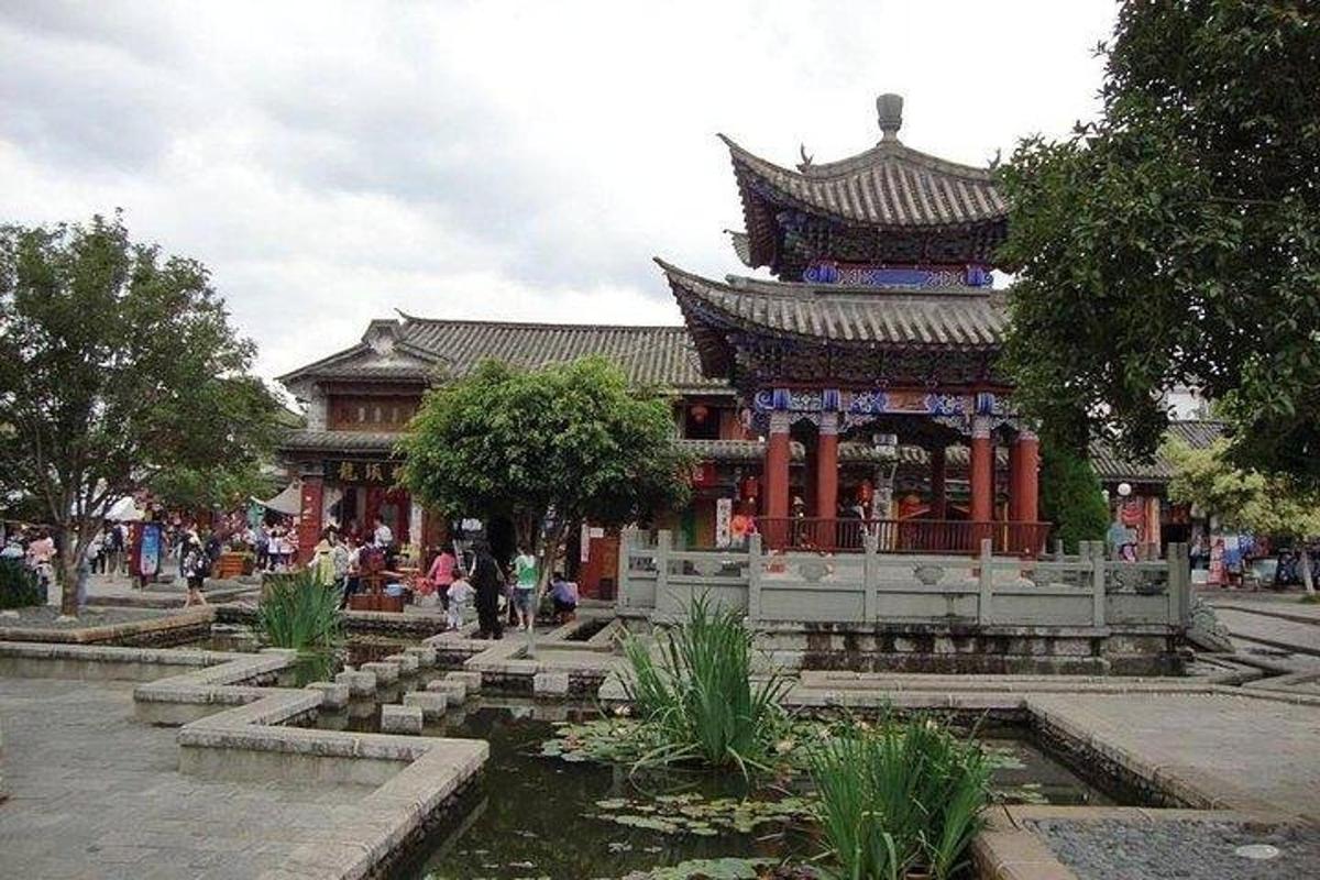 an asian building with a pond in front of it