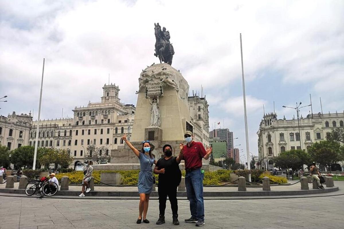 three people standing in front of a statue in front of a building