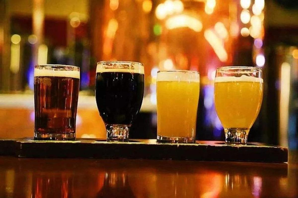 tres gots de cervesa asseguts en una barra