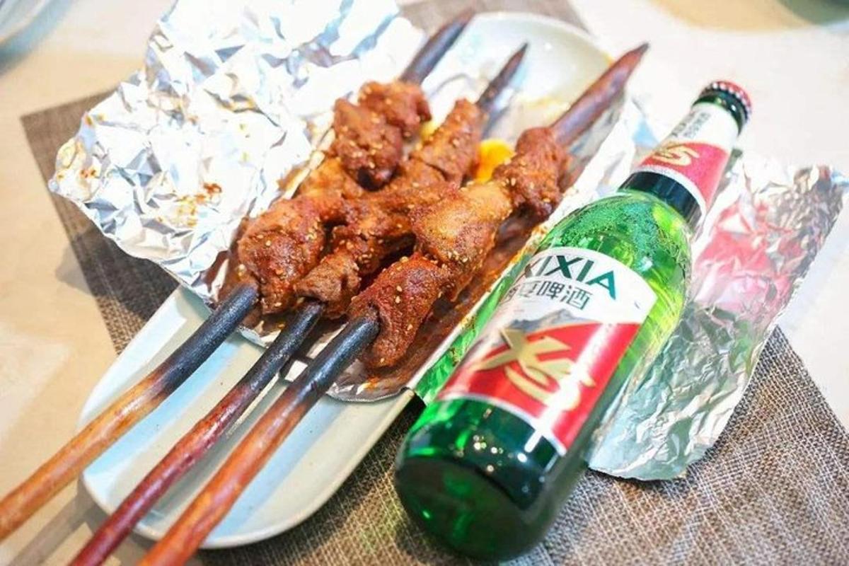 a plate of food withsticks and a bottle of soda