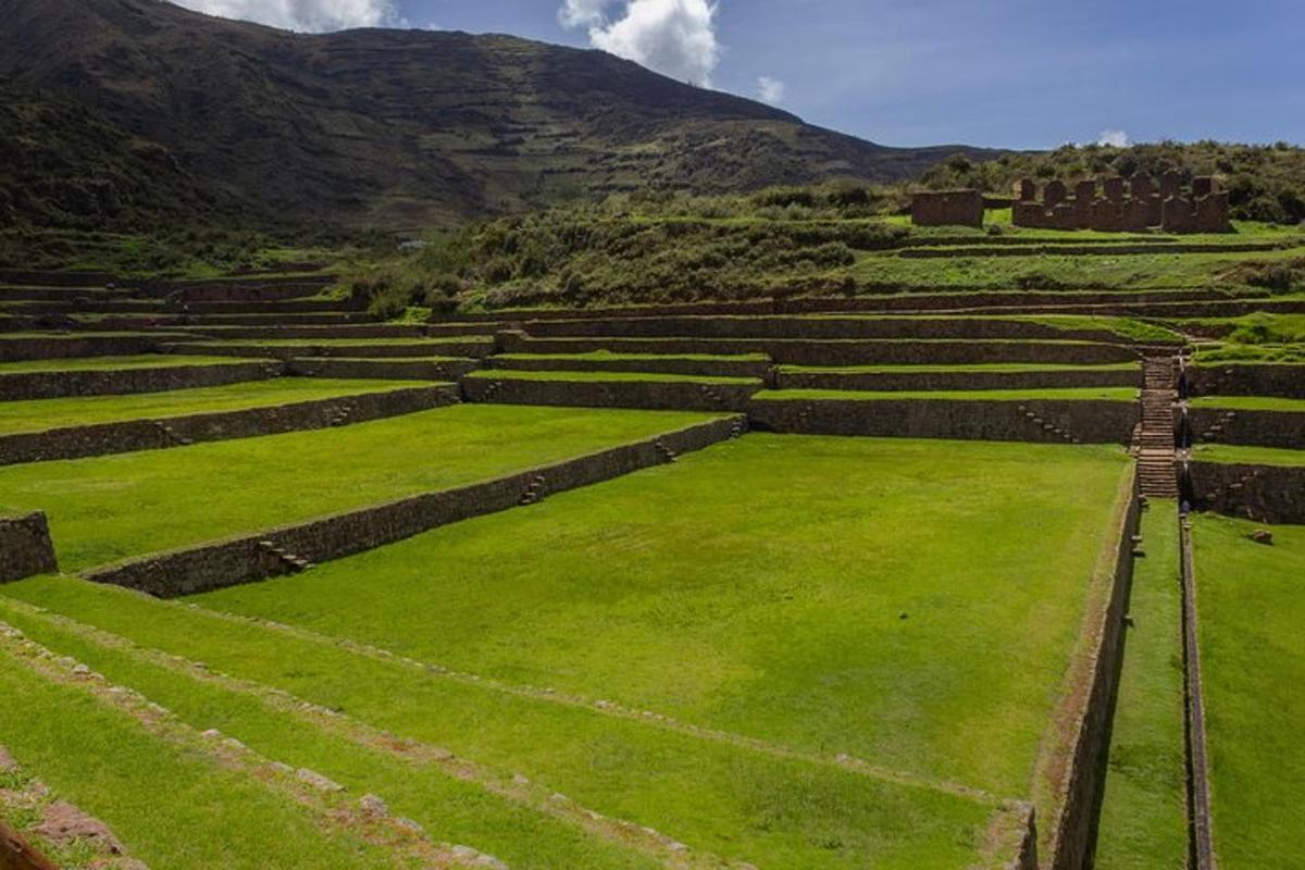 Un anfiteatro con césped verde y montañas al fondo.