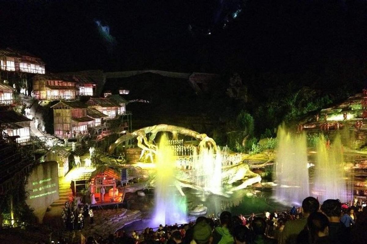 a group of people standing in front of a fountain at night