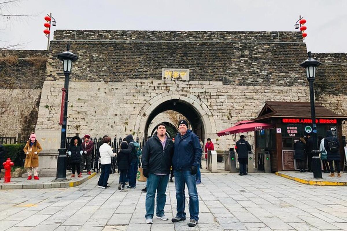 two people standing in front of a brick building