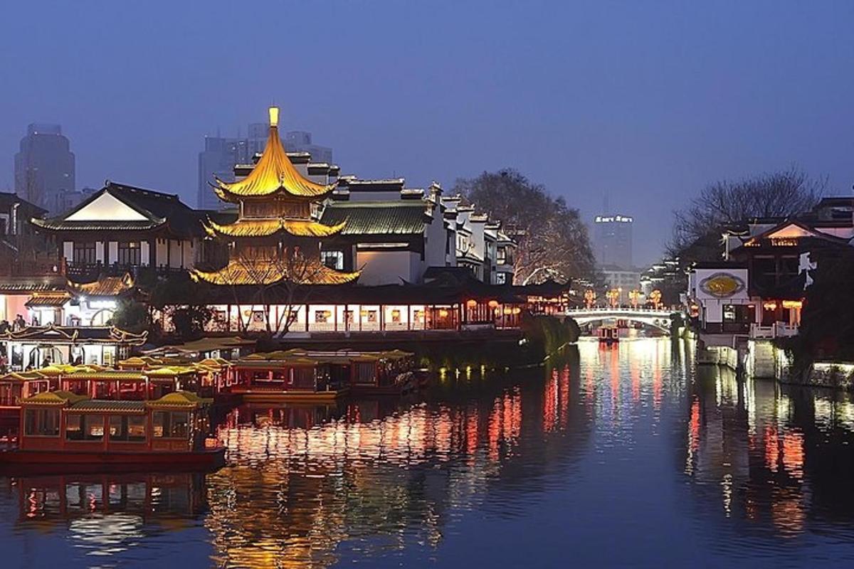 a river with a chinese building next to a city