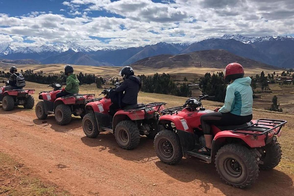 a group of people riding atvs on a dirt road
