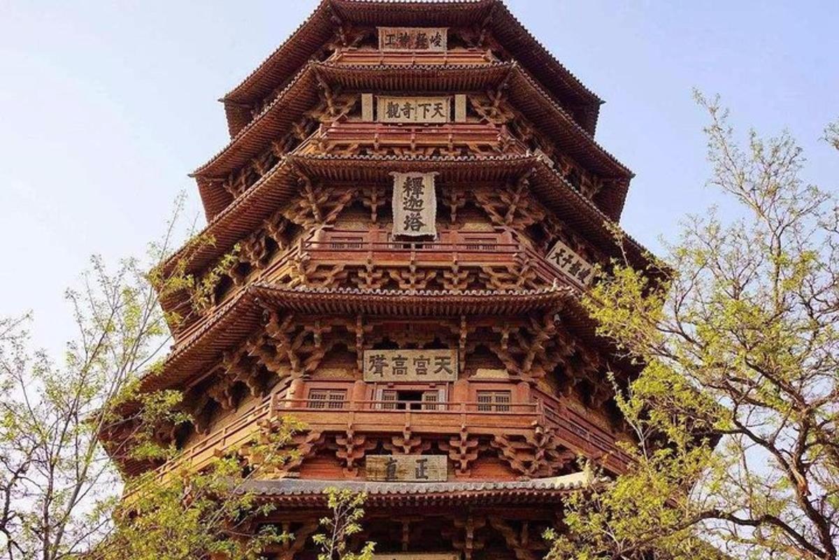 a tall wooden building with trees in front of it