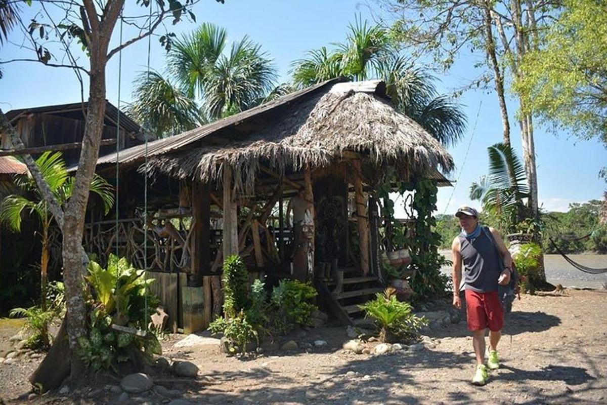 a man standing in front of a small hut