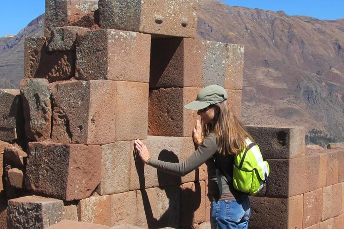 una donna che parla al cellulare accanto a un muro di mattoni