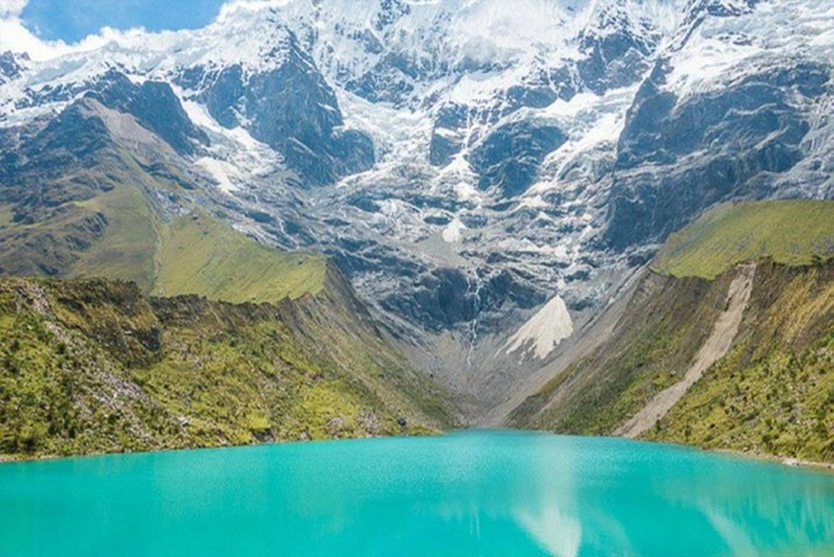 uma vista de um lago de montanha com montanhas cobertas de neve