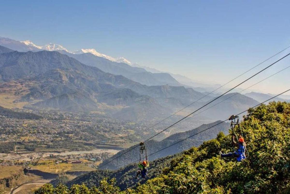 two people on a zip line on a mountain