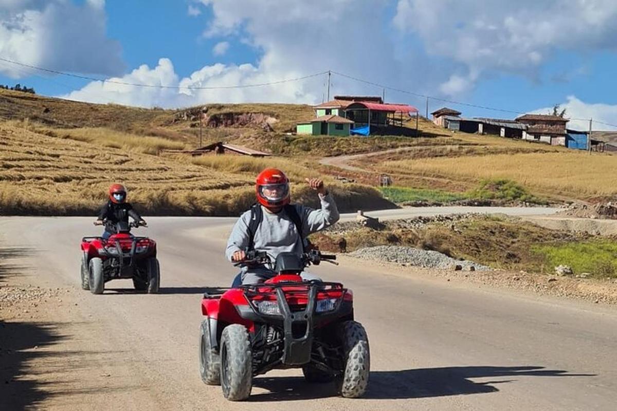 two people on atvs driving down a road