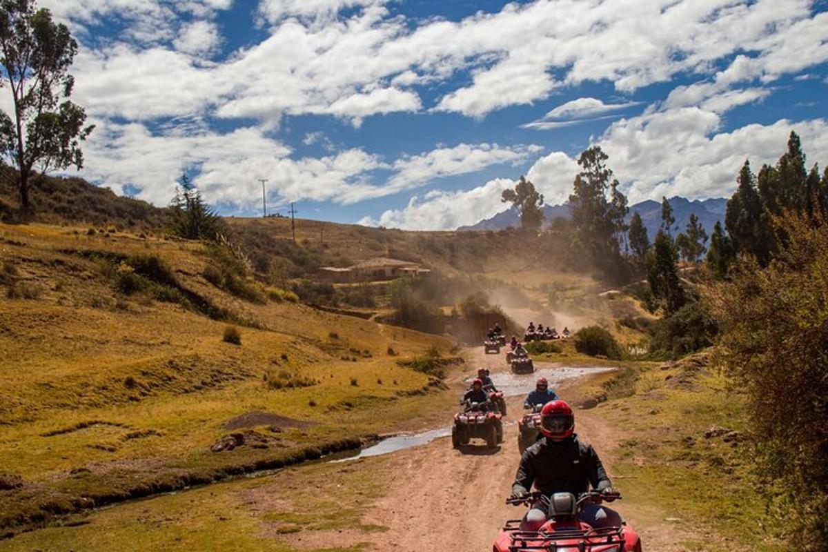 a group of people riding motorcycles down a dirt road