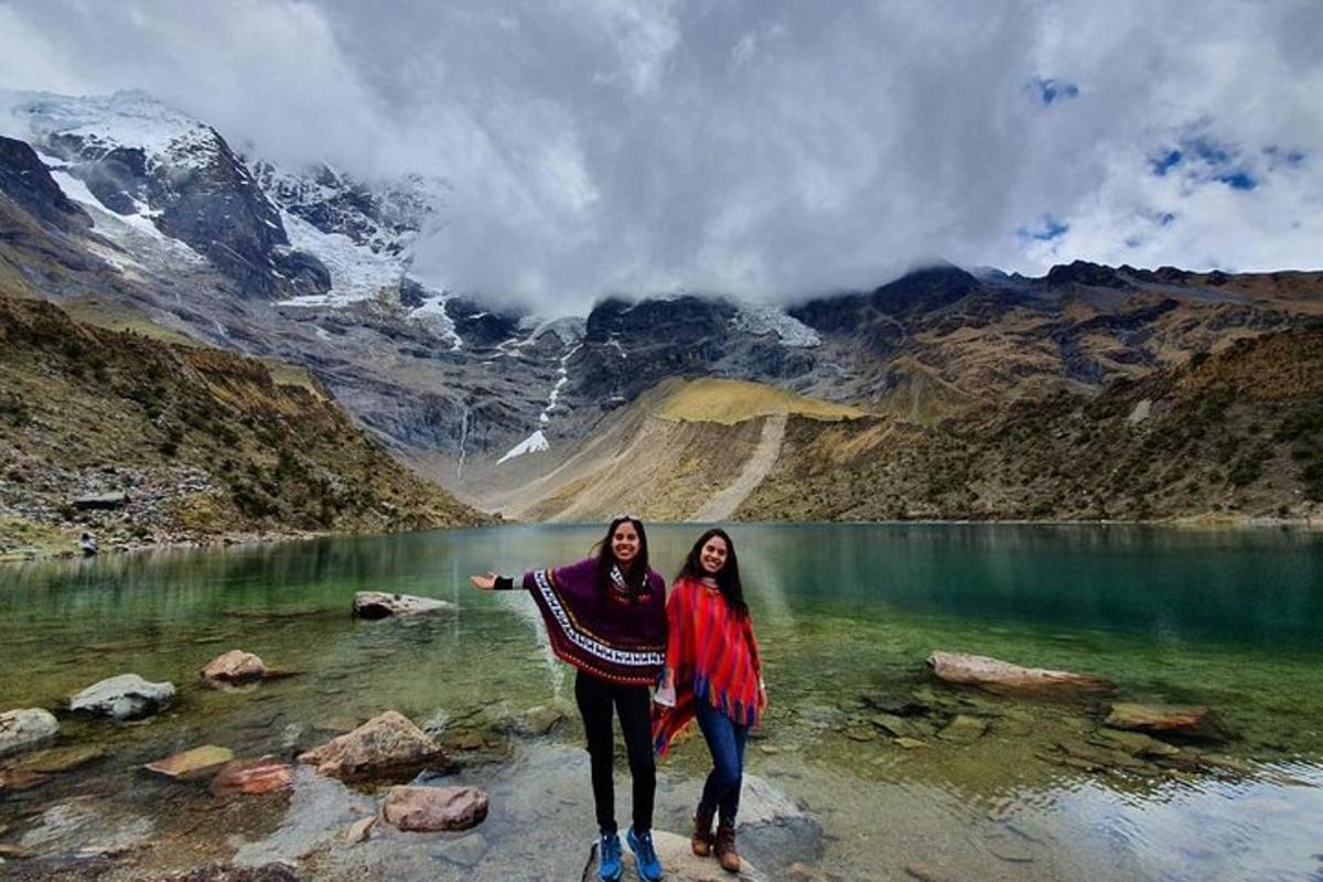 due donne in piedi davanti a un lago di montagna