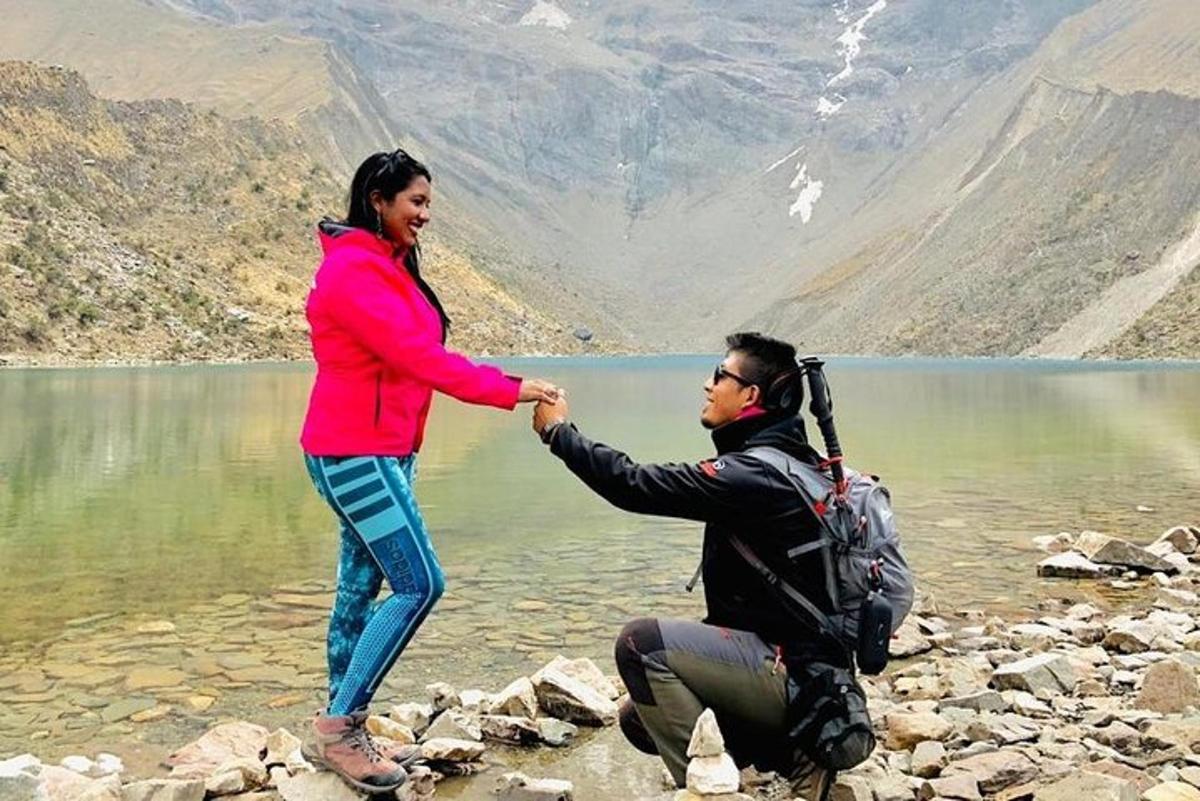 un uomo e una donna si stringono la mano vicino a un lago