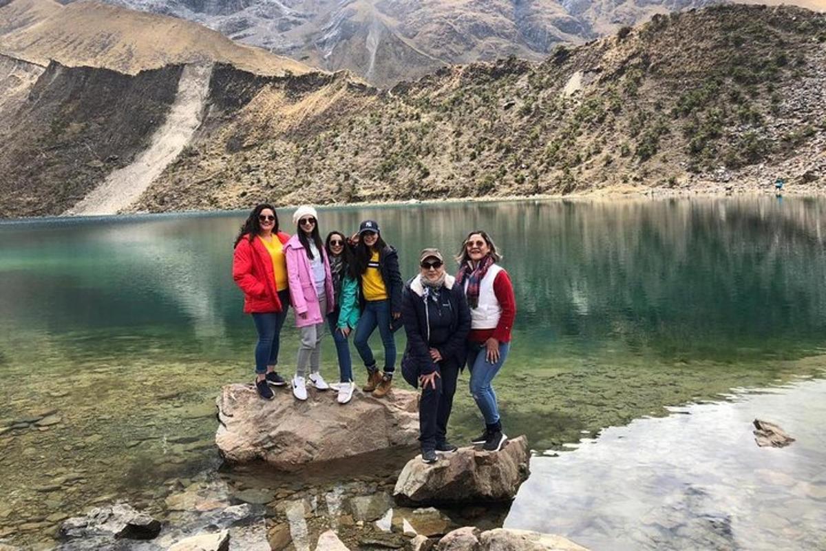 un gruppo di persone in piedi sulle rocce di fronte a un lago