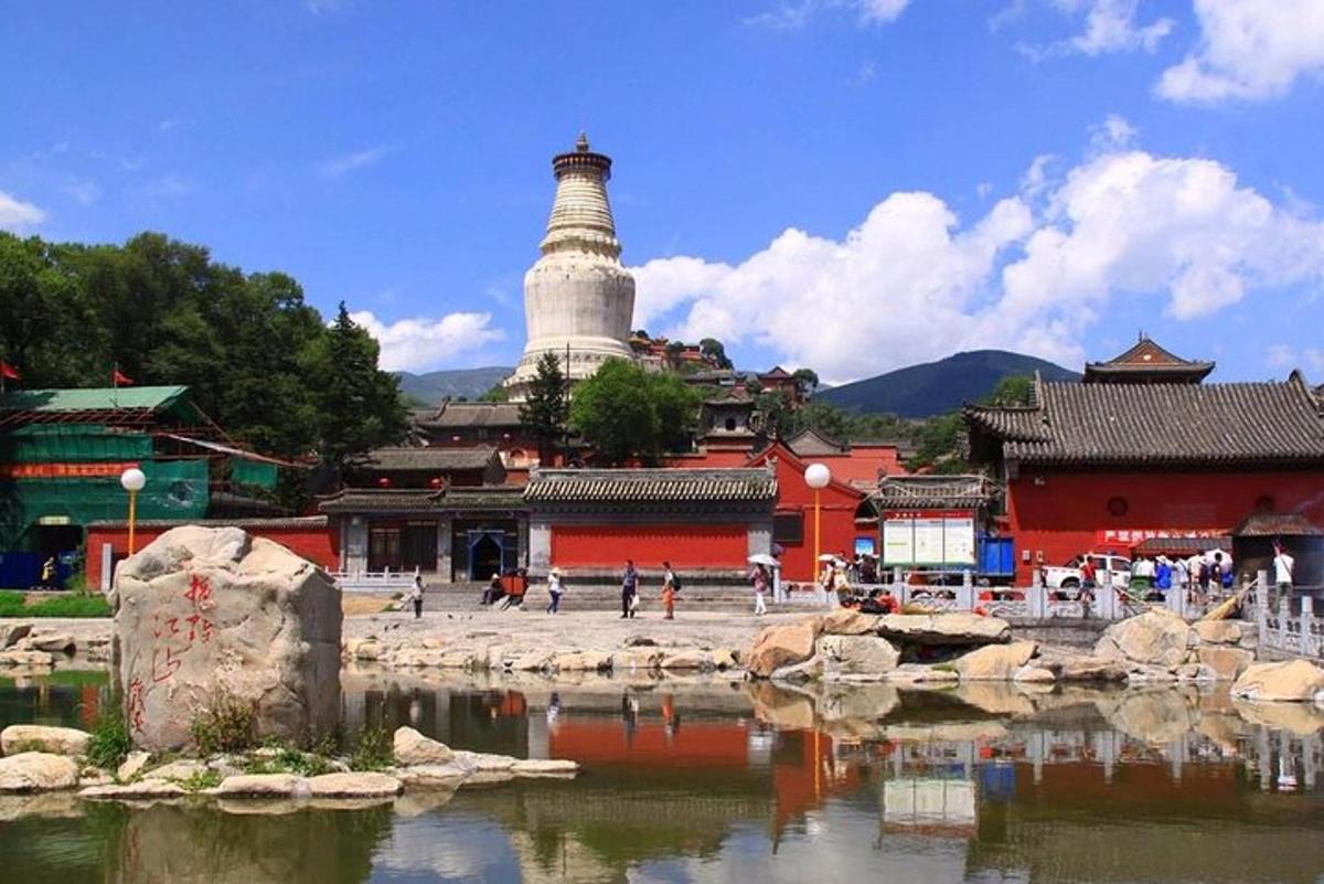a temple with a lighthouse in the middle of a body of water