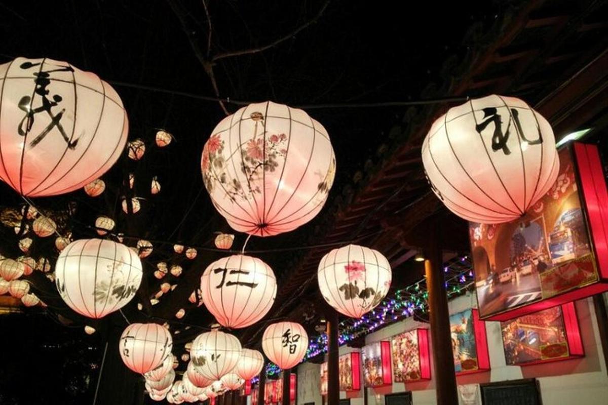 a group of pink and white lanterns hanging from a ceiling