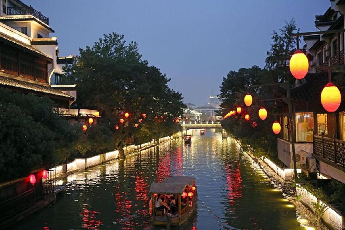 a boat traveling down a river with lanterns on it