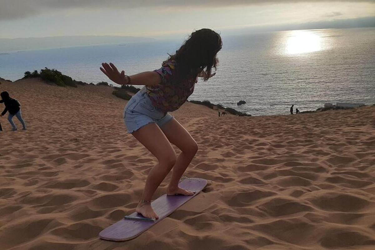 uma garotinha em pé em uma prancha de surfe na praia