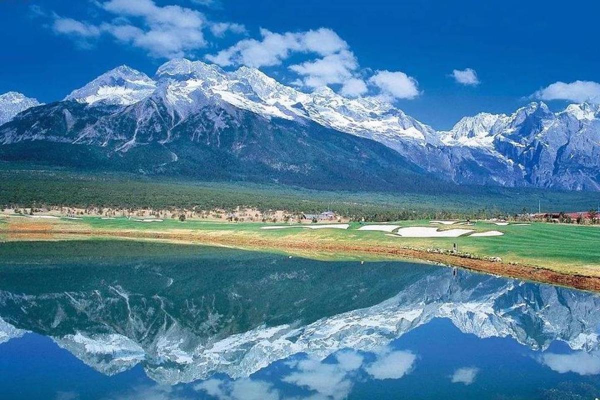 a view of a golf course with mountains in the background