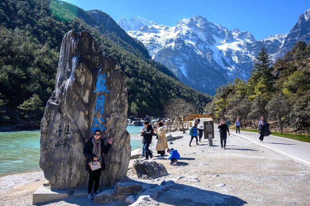 a group of people standing next to a large rock