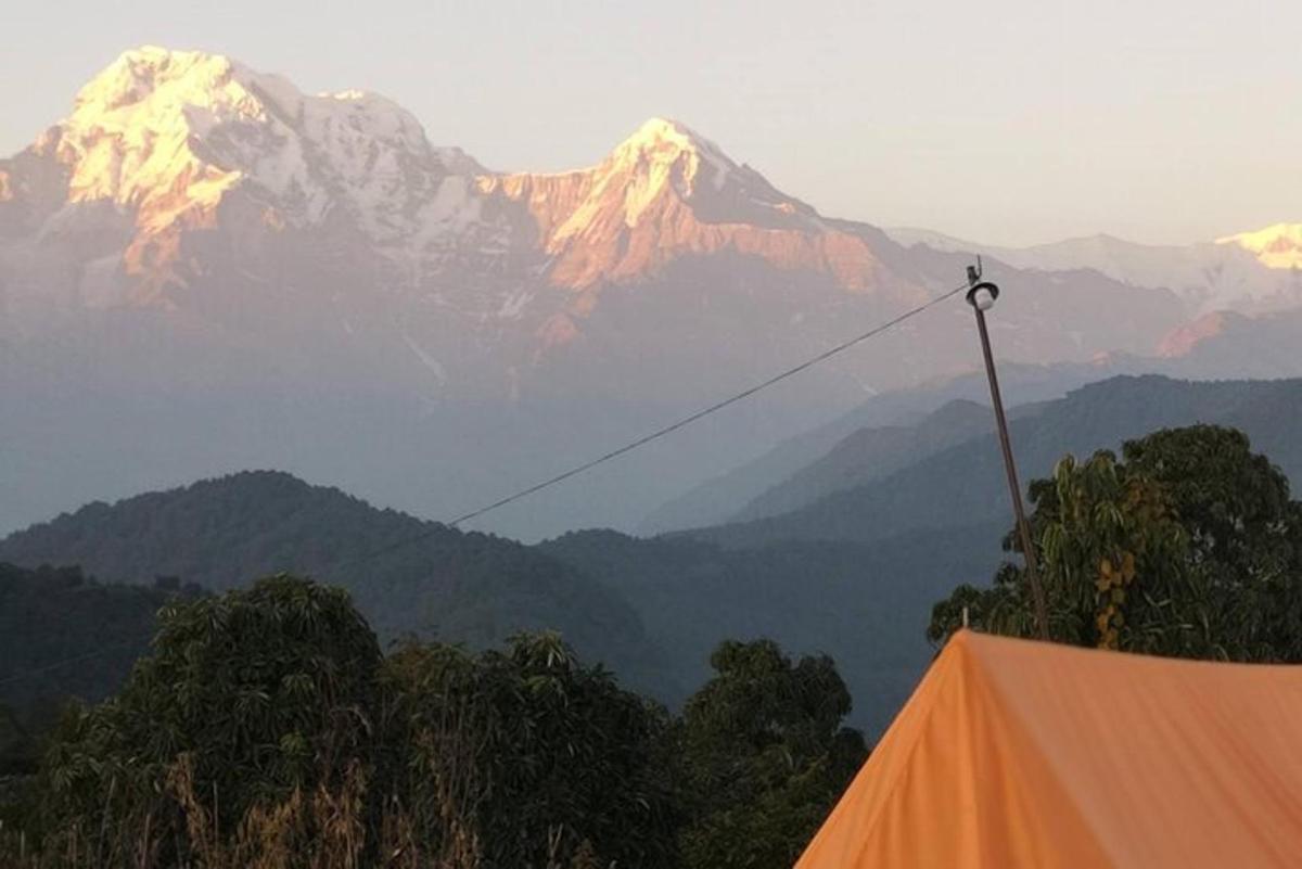 an orange tent with a mountain in the background