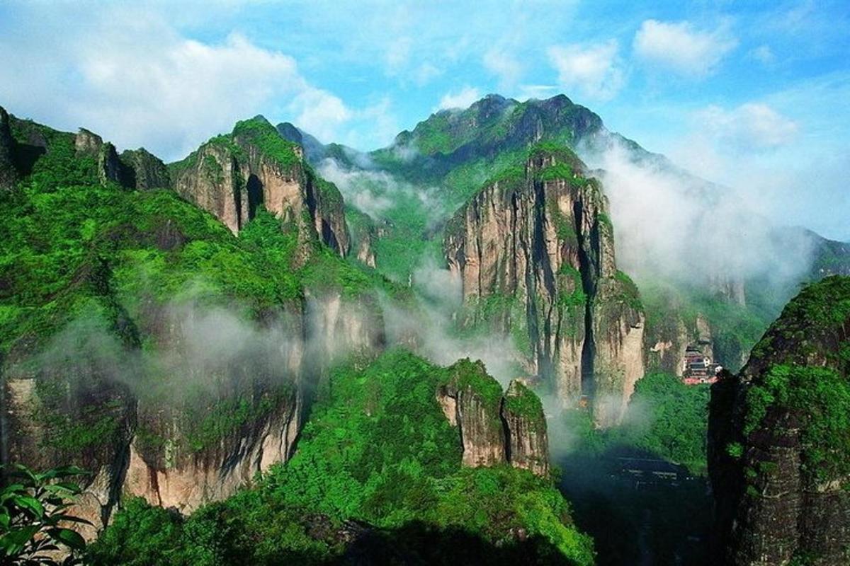 a view of a mountain range with clouds and trees