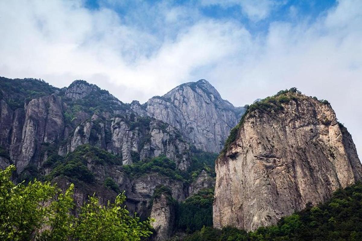 a rocky mountain with trees on it in front thereof