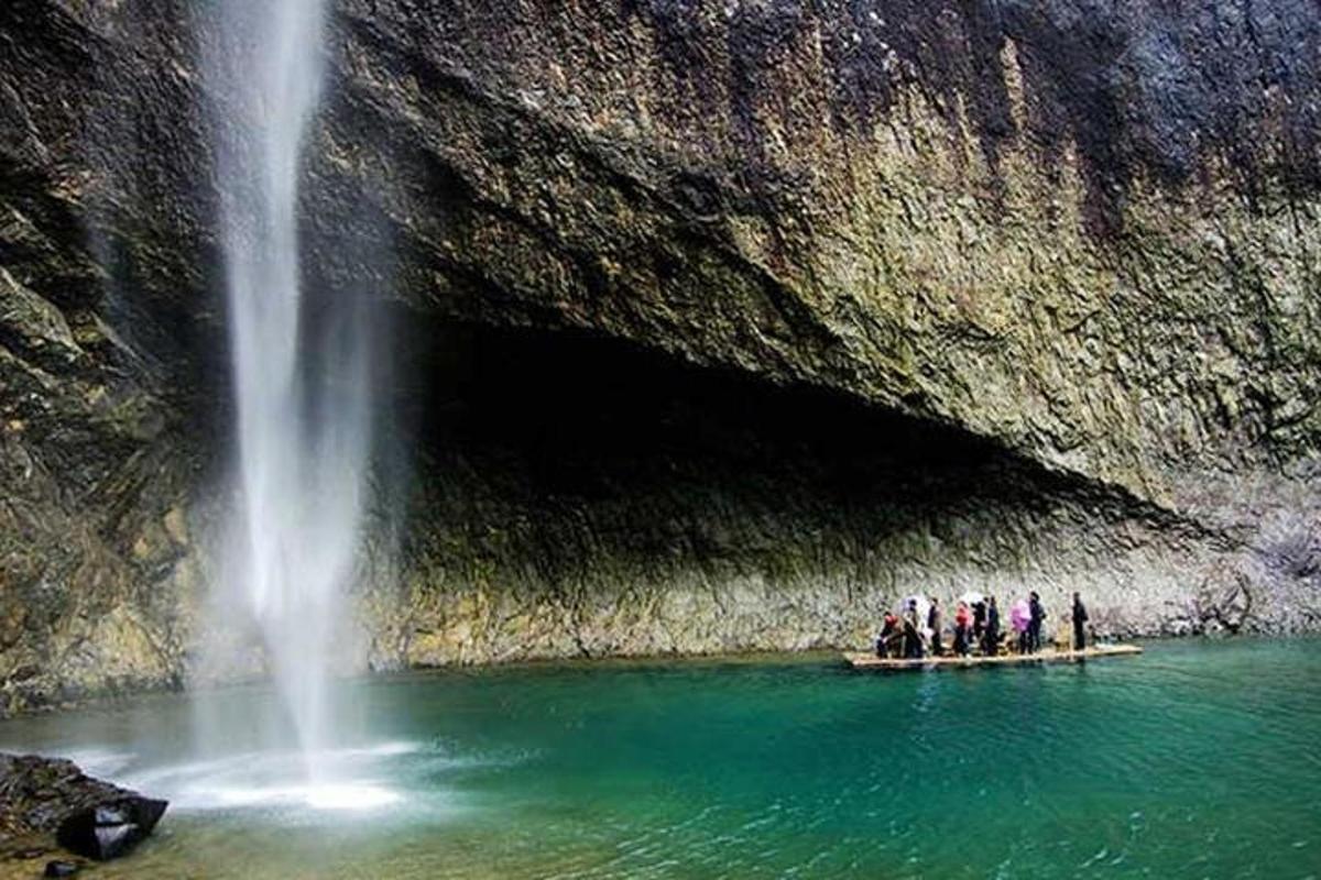 a group of people on a raft in front of a waterfall