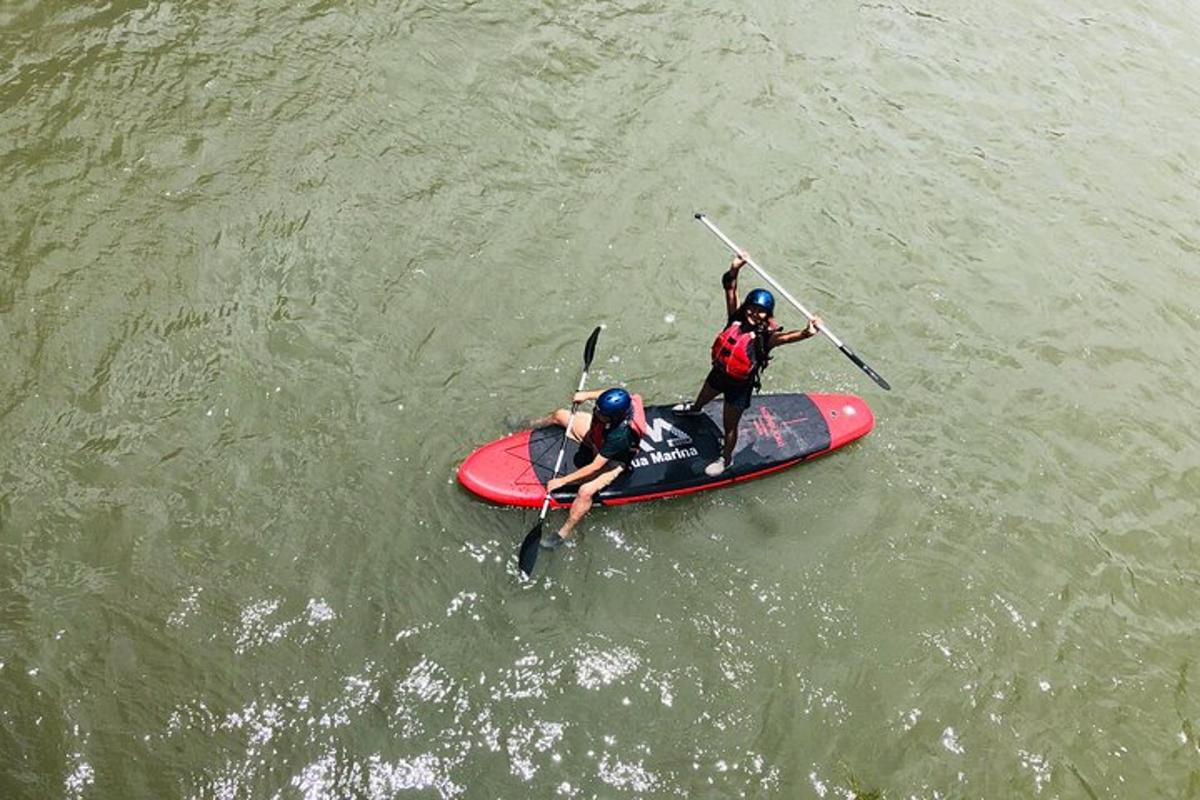 deux personnes sur une planche à pagaie dans l'eau
